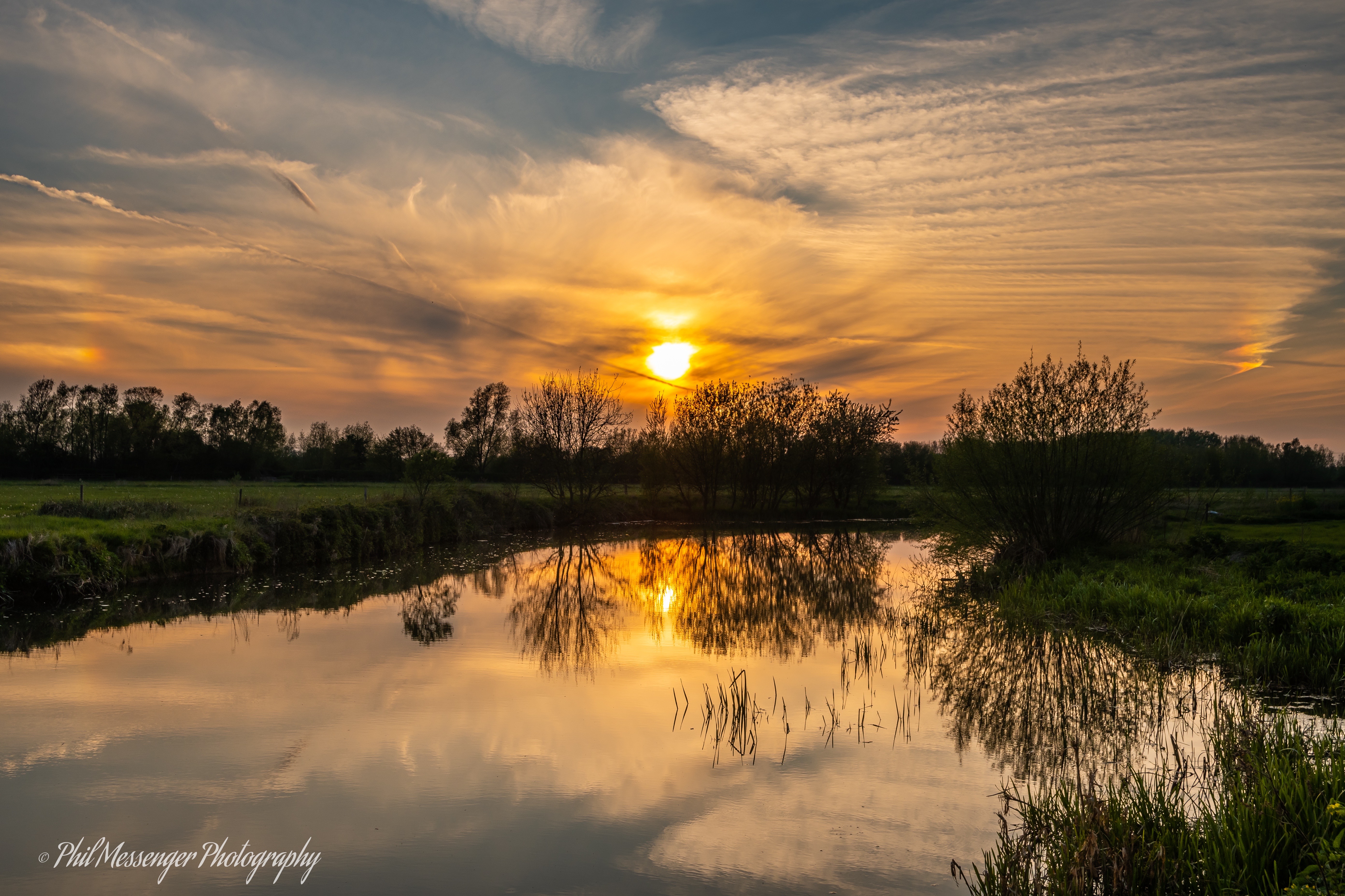Sunset over the River Thames at Lechlade Gloucestershire with sun dogs.